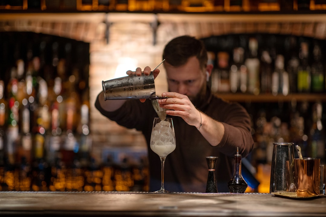 Mocktail bartender crafting colorful cocktail