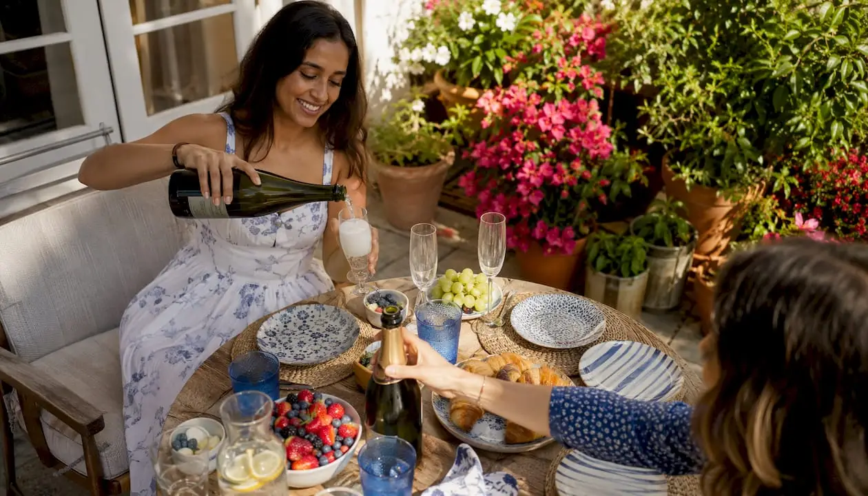 Woman pouring Prosecco at brunch table