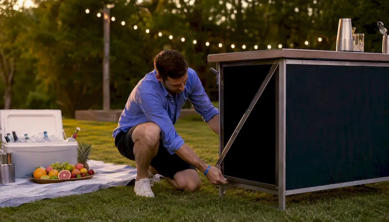 Bartender setting up folding portable bar outdoors