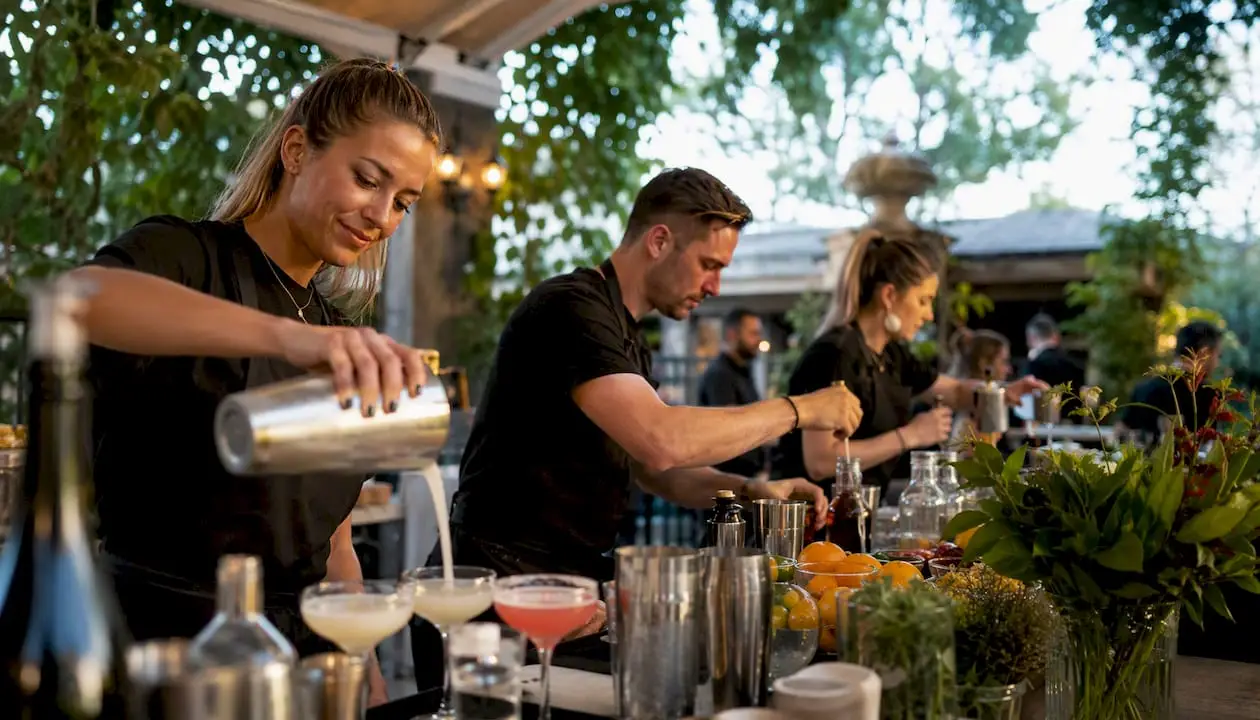 Bartenders pouring cocktails at two bar stations