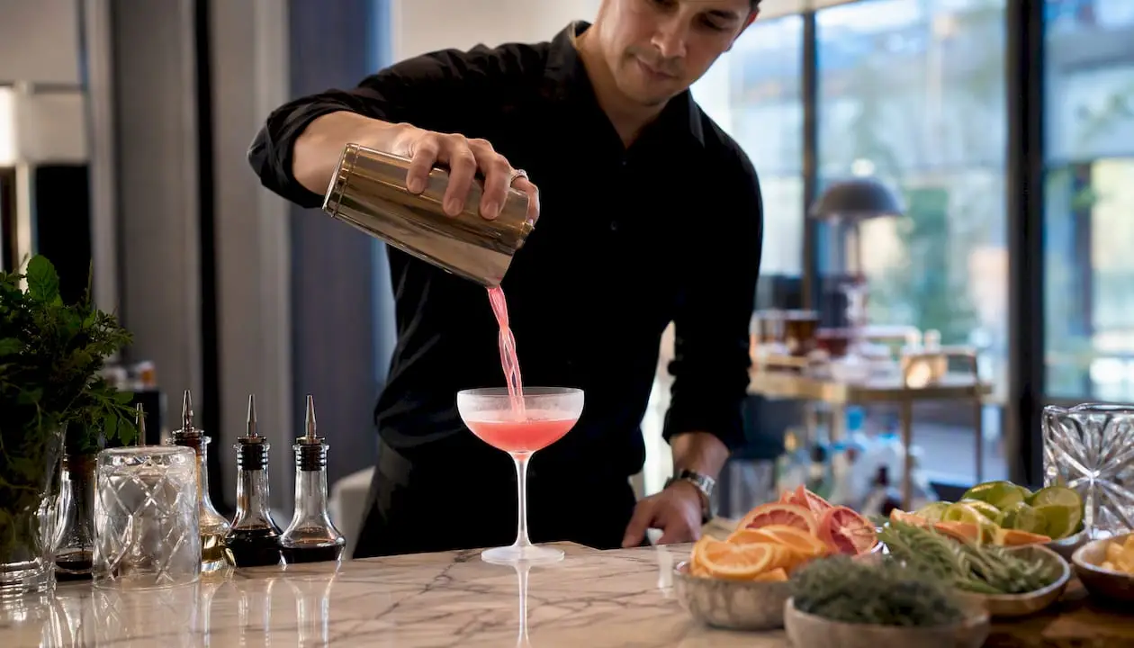 Bartender pouring cocktail during class