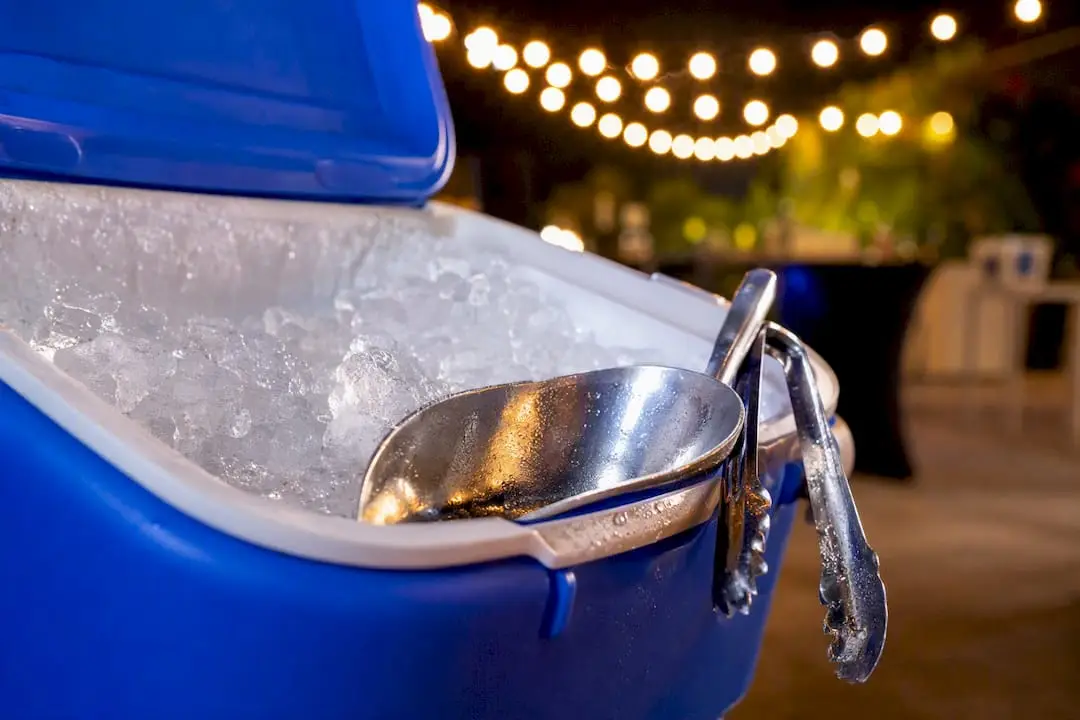 Ice scoop and tongs on cooler edge