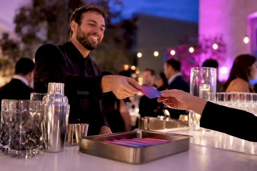 Bartender handing a drink ticket to event guest