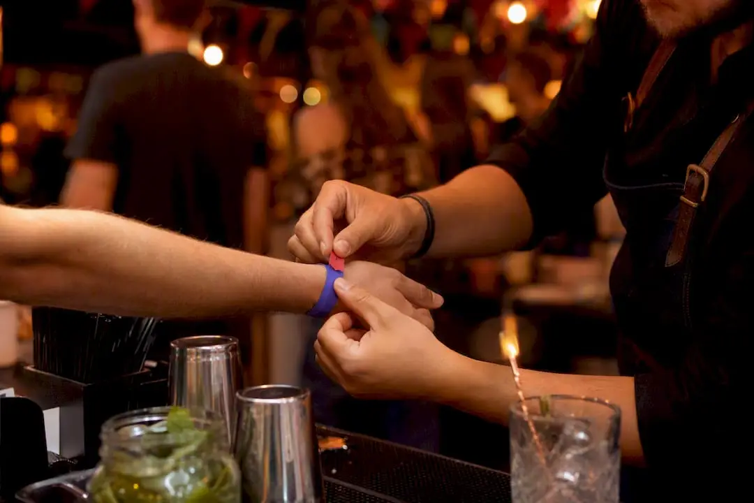 Bartender checking wristband stub at festival bar