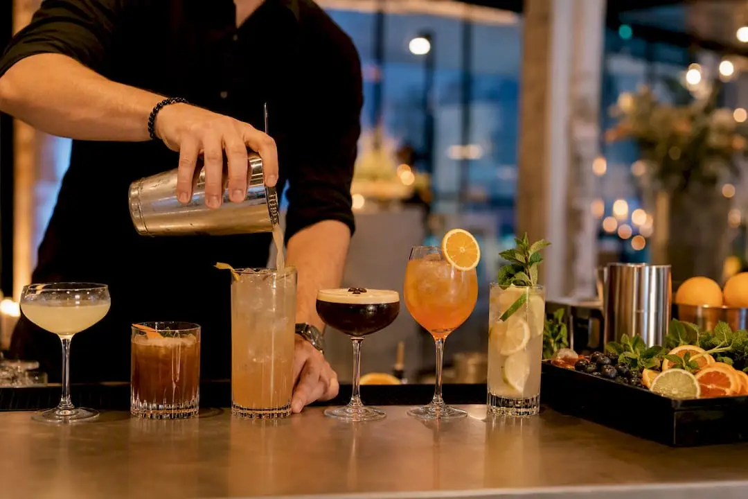 Bartender pouring a sparkling cocktail at New Year's Eve party bar