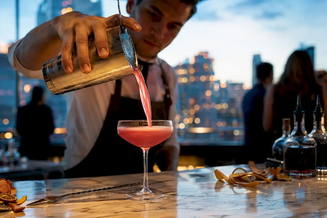 Bartender pouring cocktail at wedding bar