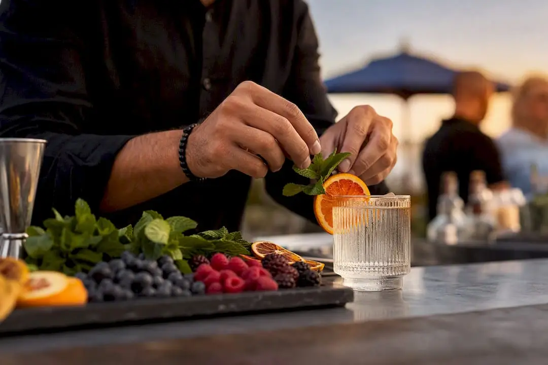 Bartender peeling citrus twist over cocktail